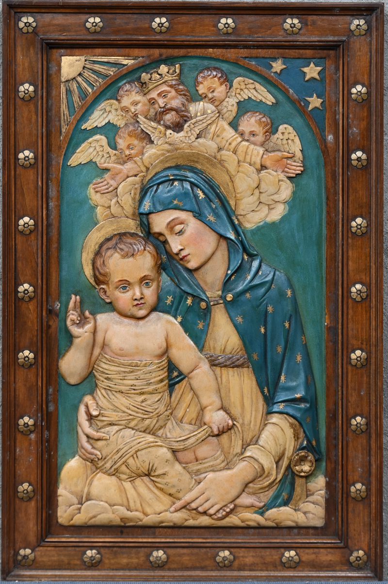 Een gepolychromeerd houten hoogreliëf met een Madonna en Kind, God de Vader en engelen. Omstreeks 1900.