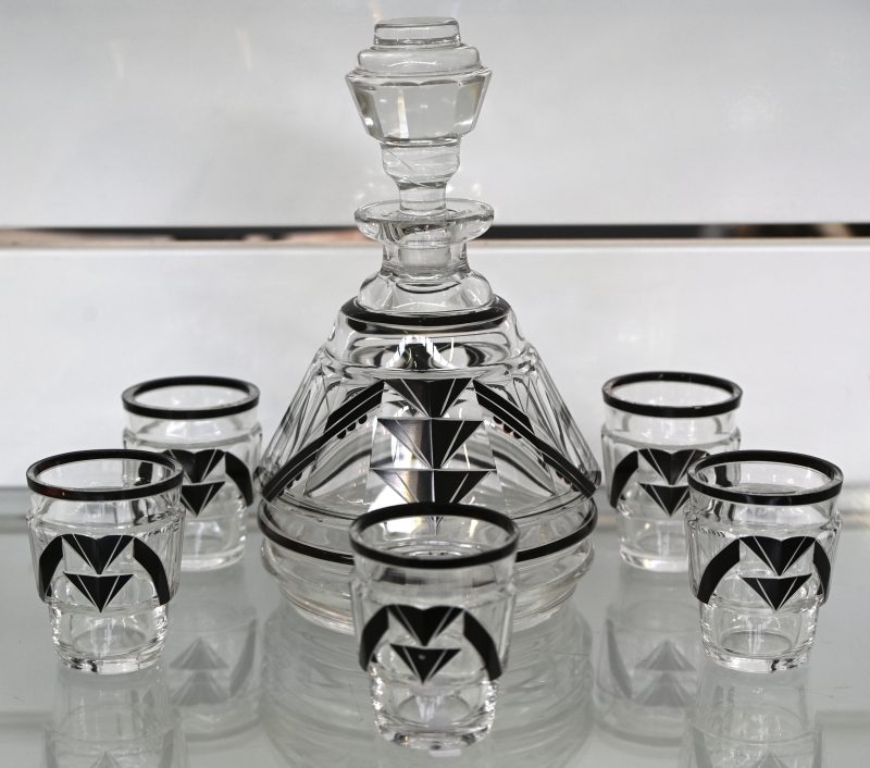 Een Art Deco Boheems kristal geslepen likeurset, bestaande uit 5 glaasjes en 1 karaf. Met geometrisch decor.