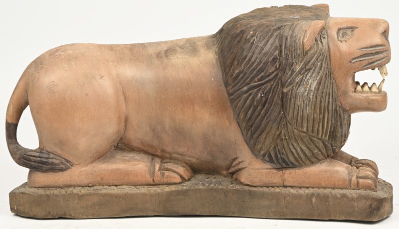 Een gesculpteerd massief houten beeld van een liggende leeuw. Afrikaans werk.
