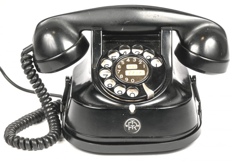 Een vintage analoge telefoon in bakeliet met draaischijf. Onderaan opschrift RTT-56, "Regie der Telegraaf en Telefoon", 1956.