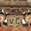Een 19de eeuwse Siciliaanse koets decoratie. In hout en smeedijzer en polychromie. Met initialen V.C. Met flankende draken in het midden.