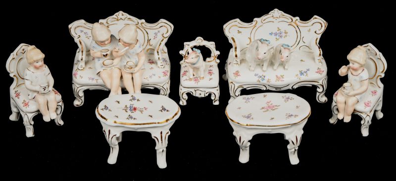 Een lot van 7 stuks 19e eeuws porseleinen beeldjes voorstellend een salonnetje met meisjes en biggetjes.