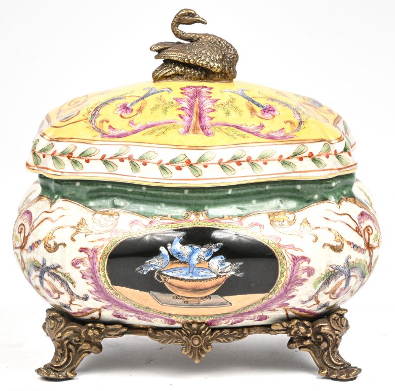 Een porseleinen tabakspot met messingen monturen en decoratie van een zwaan bovenaan in barokke stijl. Draagt merk onderaan.