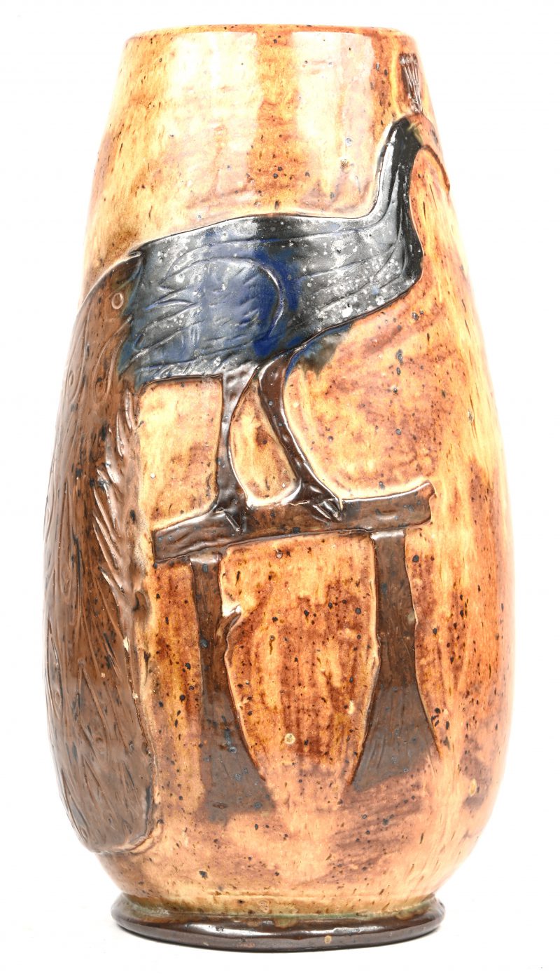 Een vaas in Vlaams geglazuurd aardewerk met de voorstelling van een pauw, onderaan gesigneerd Oscar Demoulin en gedateerd 1963.