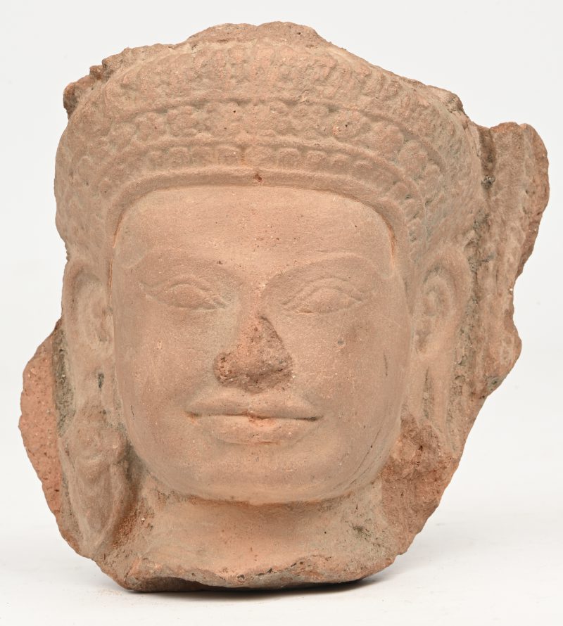 Een gesculpteerd aardewerken Boeddha hoofd.