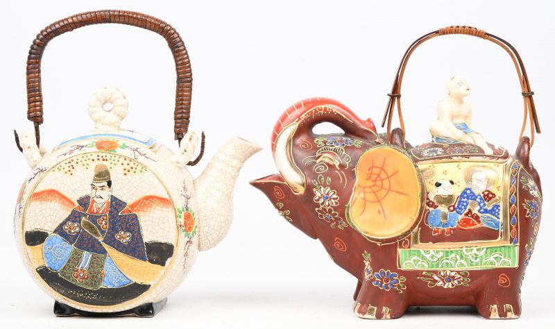 Een paar Satsuma theekannetjes met meerkleurige versieringen, waarvan 1 in de vorm van een olifant. Beide met barst in het deksel.