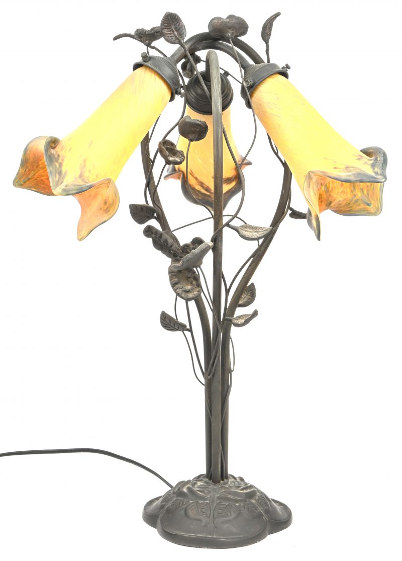 Een retro messing tafellamp met florale ornamenten. 3 lichtpunten met in glaspasta meerkleurig kelkvormige coupes.