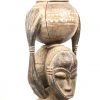 Een Afrikaans houten beeld met gesculpteerd gezinstafereel en bovenaan bolvormige pot, Congo. Zijdelingse barst in de pot aanwezig.