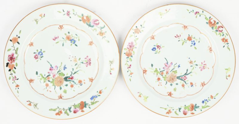Een paar 19e-eeuwse Chinese exportporseleinen borden in famille rose-stijl, handbeschilderd met bloemmotieven en vergulde randen.
