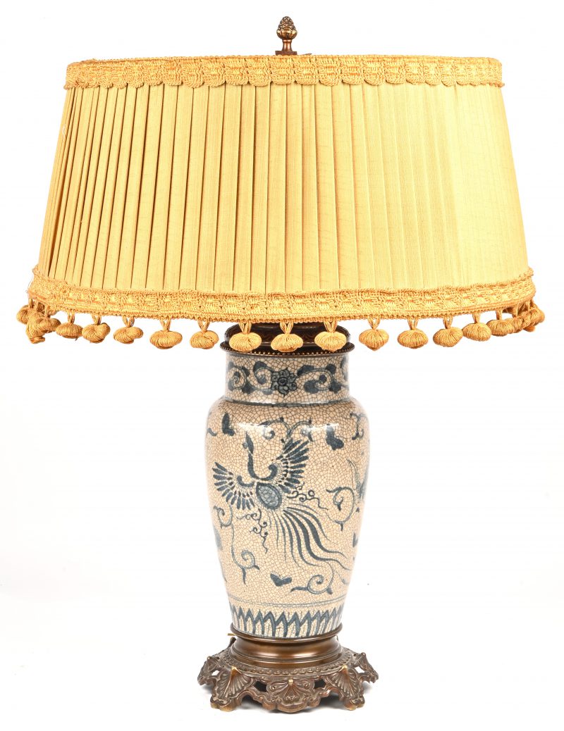 Een tafellamp met een blauw-wit Chinees porseleinen voet, bronzen delen en oude kap.
