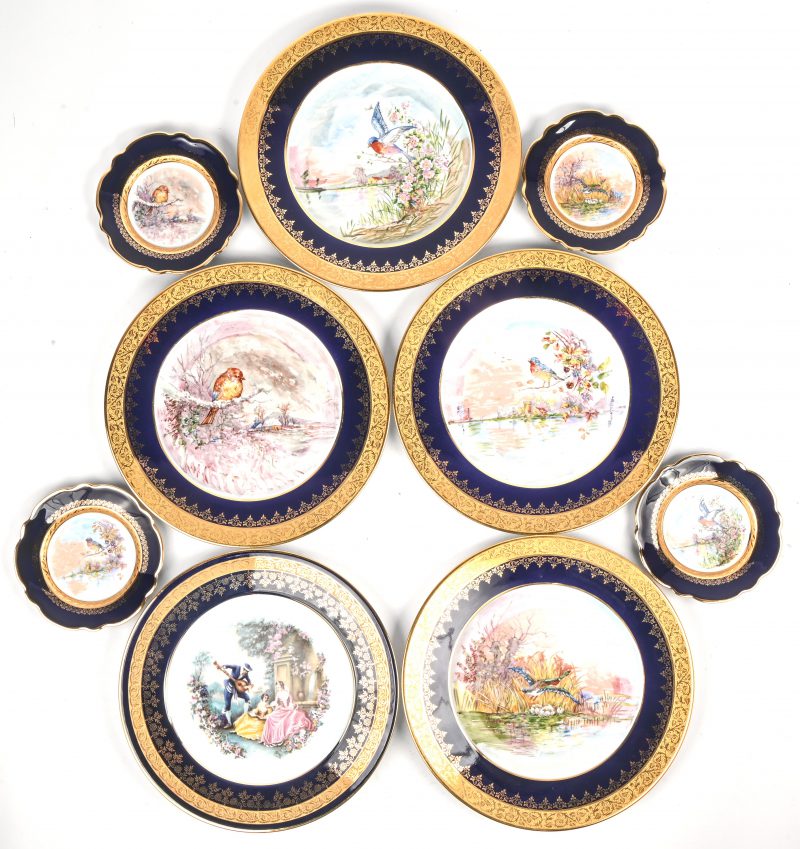 Een lot van 9 porseleinen borden, Limoges, met kobalt en goudrand bestaande uit 1 grote én 1 kleine set van de 4 seizoenen en een laatste bord met een Bard en 2 dames.