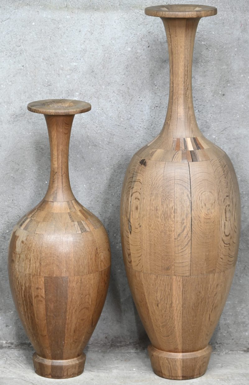 Een set van 2 grote houten vazen toegeschreven aan De Coene Frères uit de eerste helft van vorige eeuw. Vertonen barstjes en geloste naden, de kleinste vaas is aan de kraag gelijmd.
