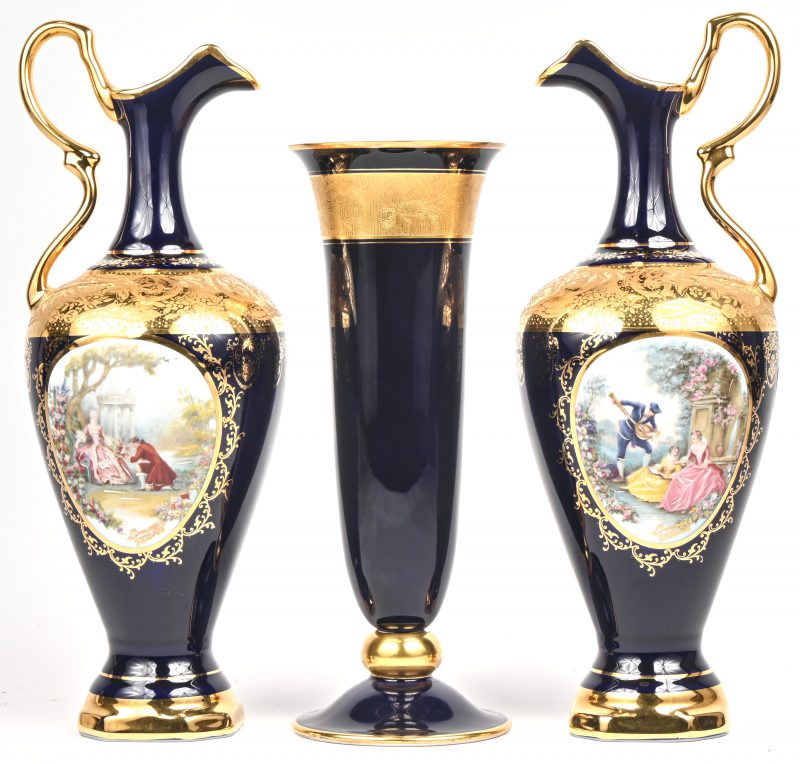 Een lot van 2 kannen en een vaas in porselein, kobaltblauw met een rijkelijk vergulde versiering. De kanne zijn getekend Limoges en de vaas Bavaria.