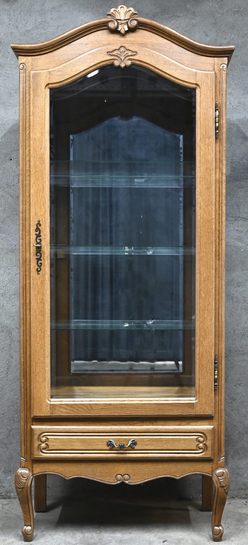 Een eikenhouten vitrinekast in Bretoense stijl en geslepen glas, één deur en één lade.