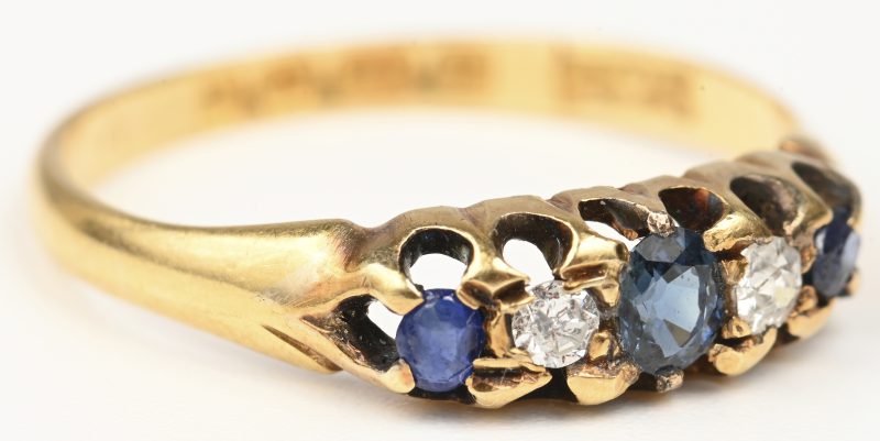 Een 18 kt geelgouden ring bezet met twee diamanten oude slijp en drie saffieren met een gezamenlijk gewicht van +- 0,30 ct.