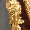 Een gefineerde cartel met console in Lodewijk XV-stijl, rijkelijk versierd met vuurvergulde bronzen en getooid door een alegorie op de tijd. Blauwe Romeinse cijfers, drie sleutelgaten. Achteraan gemerkt C. Personne à Amiens.