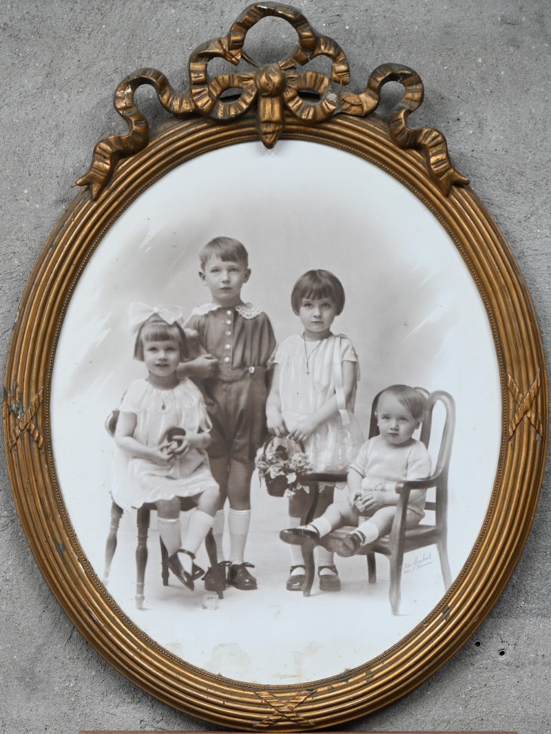 Een familieportret in een gebeeldhouwde en vergulde ovale lijst. Gesigneerd door de fotograaf Edm. Marchant te Leuven 1925.