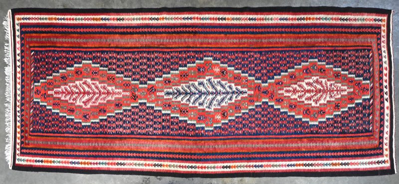 Een tapijt, Senneh kelim uit Iran, in wol op wol met drievoudig medaillon met levensbomen en botehmotiefjes.