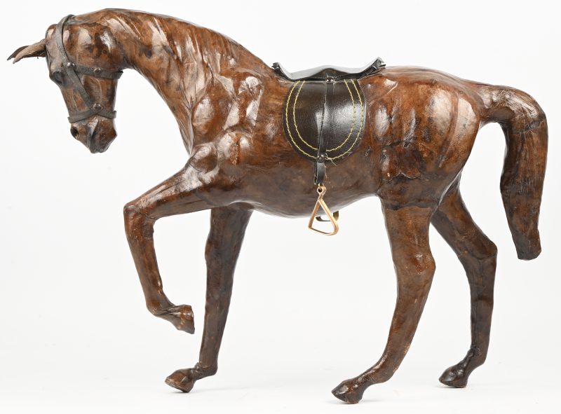 Een beeld van een paard in leder, met zadel.