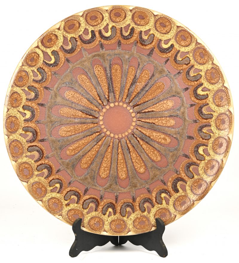 Een grote vintage schotel in aardewerk, een bloemmotief in bruintinten. Onderaan gemerkt op sticker ‘CFK’ en draagt een initiaal.
