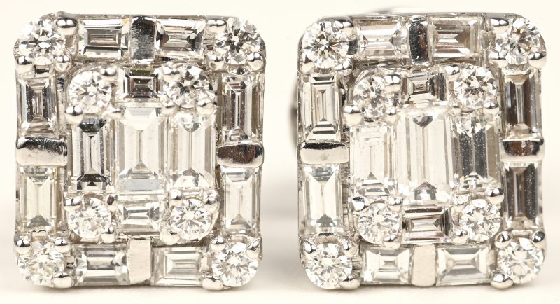 Een paar 18 kt witgouden oorbellen bezet met briljanten en diamanten baguetten met een gezamenlijk gewicht van +- 1,10 ct.