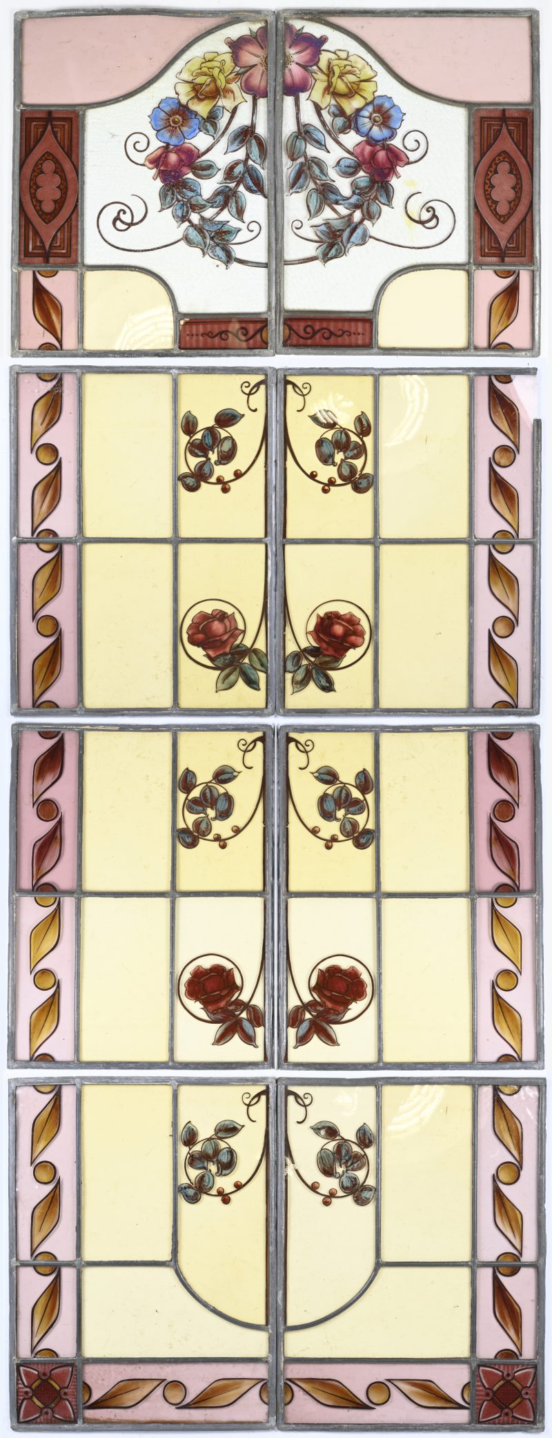 Een paar glas-in-loodramen voor een dubbele deur telkens uit 8 panelen. Periode interbellum. Met floraal decor. Meerdere beschadigingen aan de tweede set.