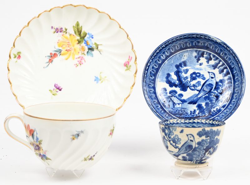 Een lot met twee kop-en-schotels bestaande uit één met kleurrijke bloemmotief met gouden rand en één van blauw-wit Chinese porselein met traditionele motieven.