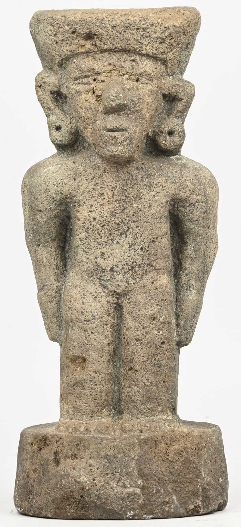 Een uit vulkanisch gesteente gesculpteerd beeldje van een staand figuur, in precolumbiaanse stijl.