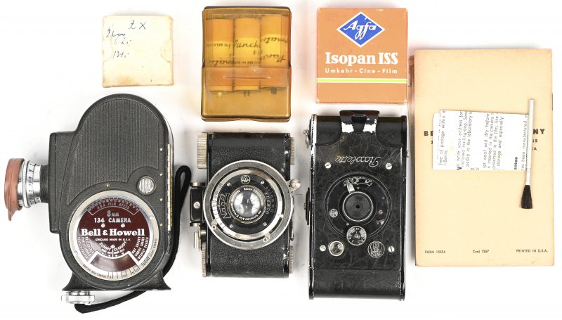 Een lot vintage camera-apparatuur uit de 20e eeuw, bestaande uit een Voigtländer V.P. twin-lens meetzoekercamera met Compur-lens (1930-1940), een Bell & Howell 8mm filmcamera model 134 van metaal en bakeliet (ca. midden 20e eeuw), en een Agfa Synchro-Box camera van zwart metaal met lederen bekleding (ca. midden 20e eeuw). Bijgevoegd wat andere toebehoren.