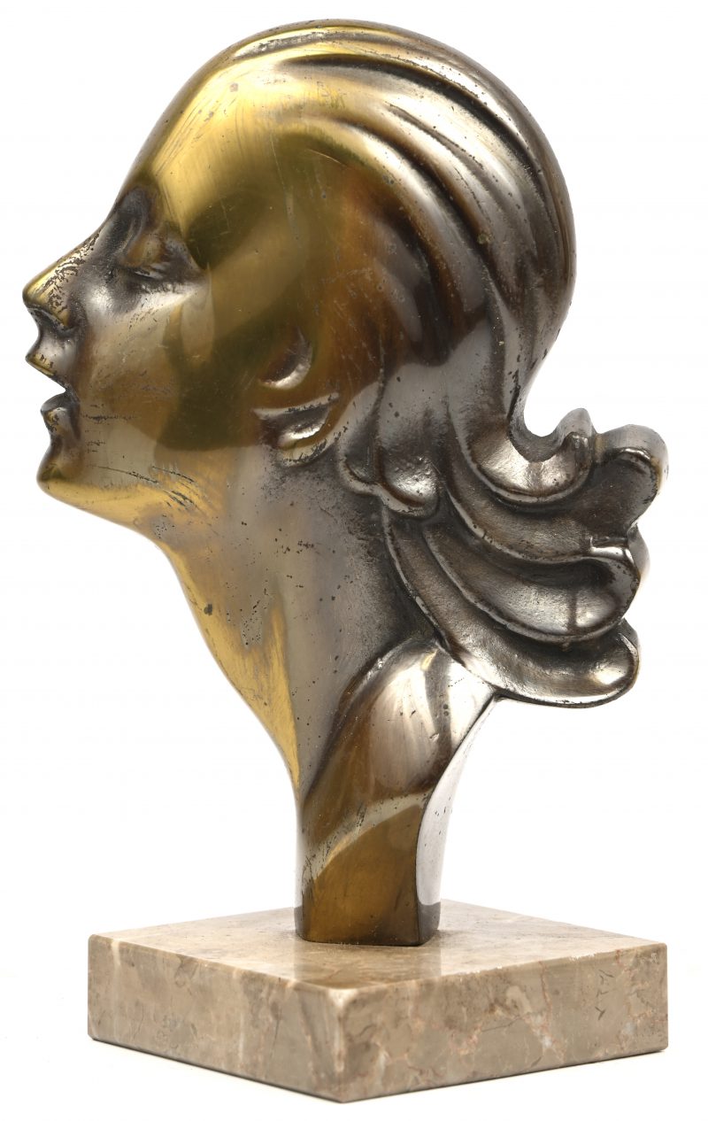 Een bronzen art-deco vrouwenprofiel op marmeren voet.