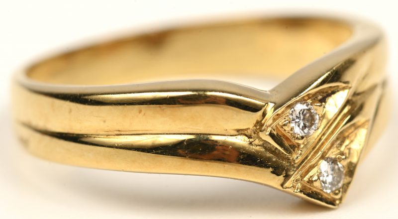 Een 18 kt geelgouden ring bezet met twee briljanten met een gezamenlijk gewicht van +- 0,10 ct.