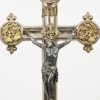 Een verzilverd metalen crucifix met vergulde elementen.