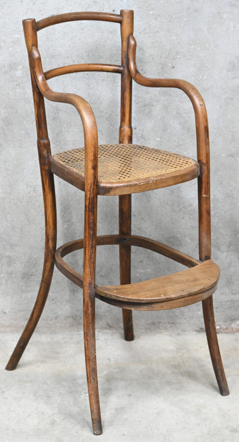 Een kinderstoeltje van stoomgebogen beukenhout met rieten zit. In de geest van Thonet.