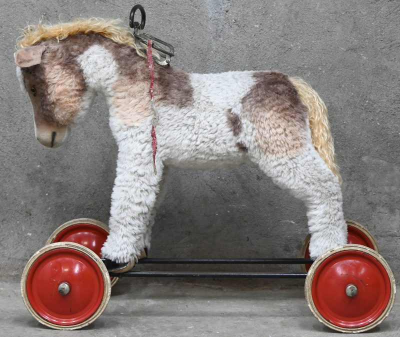 Een vintage speelgoed ezeltje op wieltjes. In het oor gemerkt.