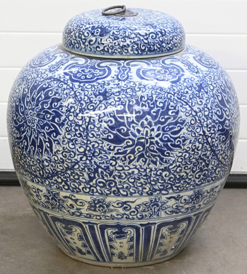 Een grote Chinees porseleinen doppot, blauw-wit met floraal decor.