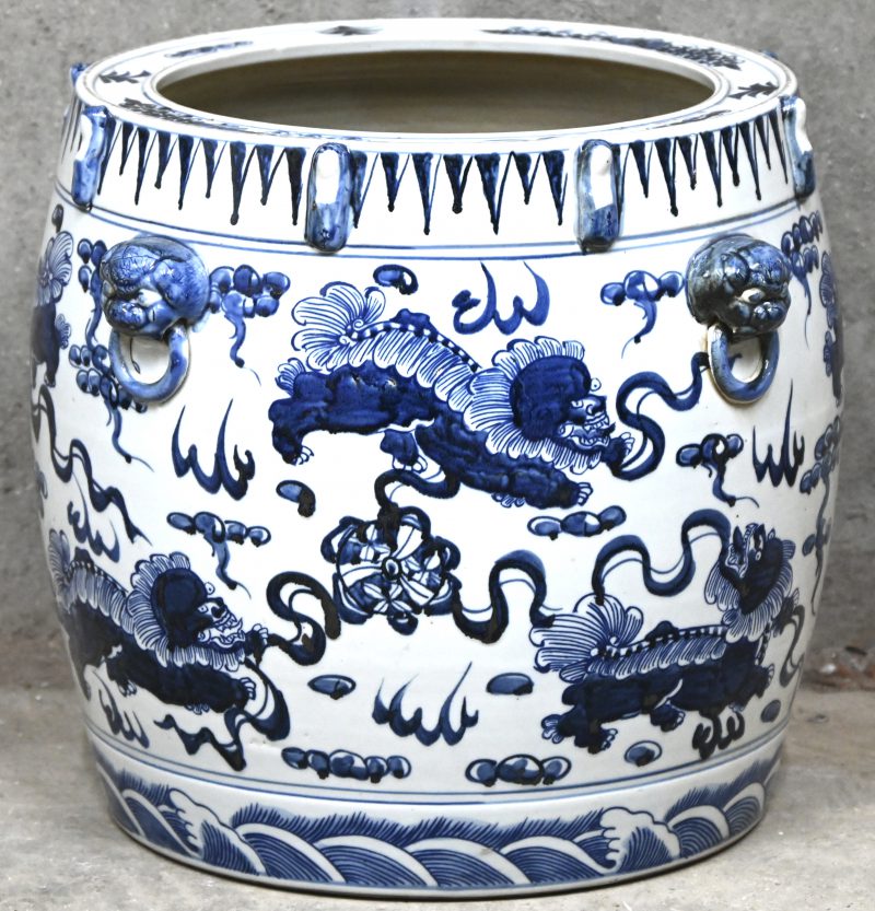 Een grote Chinees porseleinen cache-pot, blauw-wit met draken in het decor en foo honden versierd.