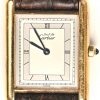 Een verguld zilveren polshorloge, Must De Cartier met achteraan de vermelding Cartier Paris 925 tank quartz argent plaque or g 20 m Swiss made.