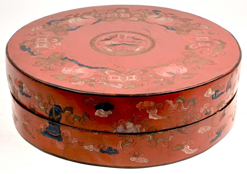 Een Chinese roodgelakte lunchbox met decor met vleermuis en vissen.