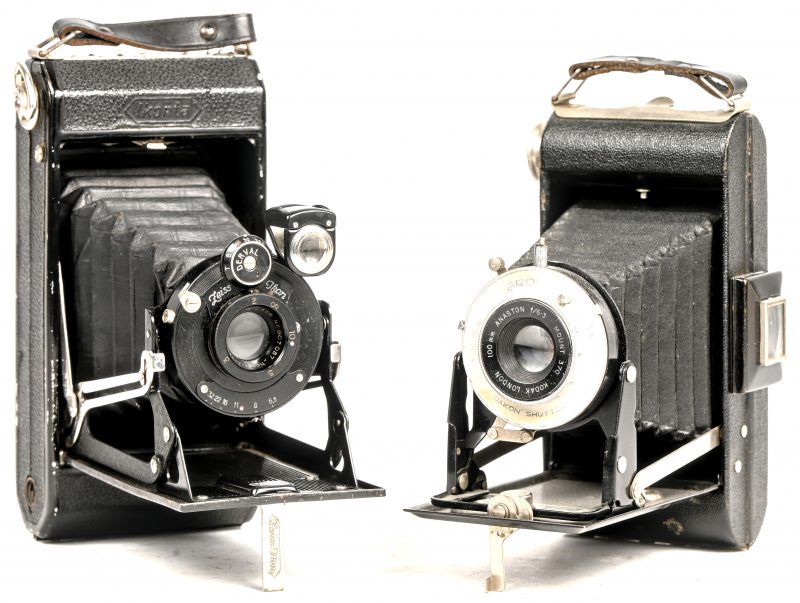 Een lot oude vouwcameras bestaande uit een Kodak Brownie met Anaston 100mm f/6.3 lens en een Zeiss Ikon met Novar Anastigmat 105mm 1.6.3 lens. Beide in lederen etui.