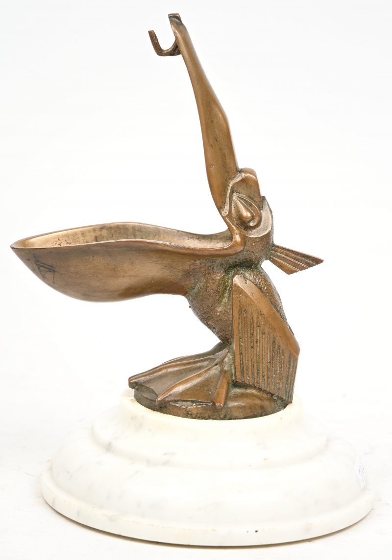 “Pelican”, een bronzen beeldje op wit marmeren sokkel, draagt een restant van een handtekening. Naar Max Le Verrier.