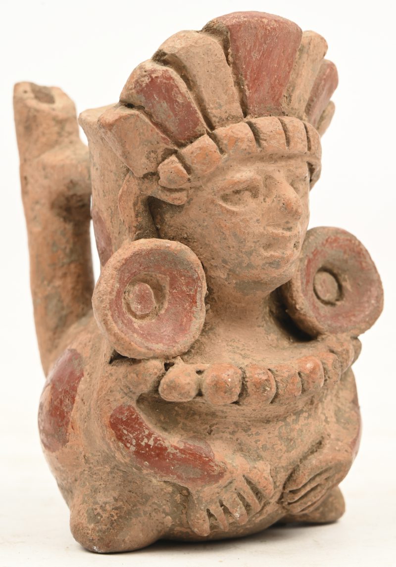 Een aardewerken kruikje in Zapotec stijl met afbeelding van een figuur met hoofdtooi en oorringen.