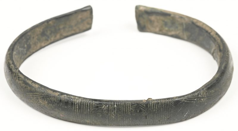 Een bronzen armband met gegraveerde lijnen in het decor. Vermoedelijk Oud-Romeins.