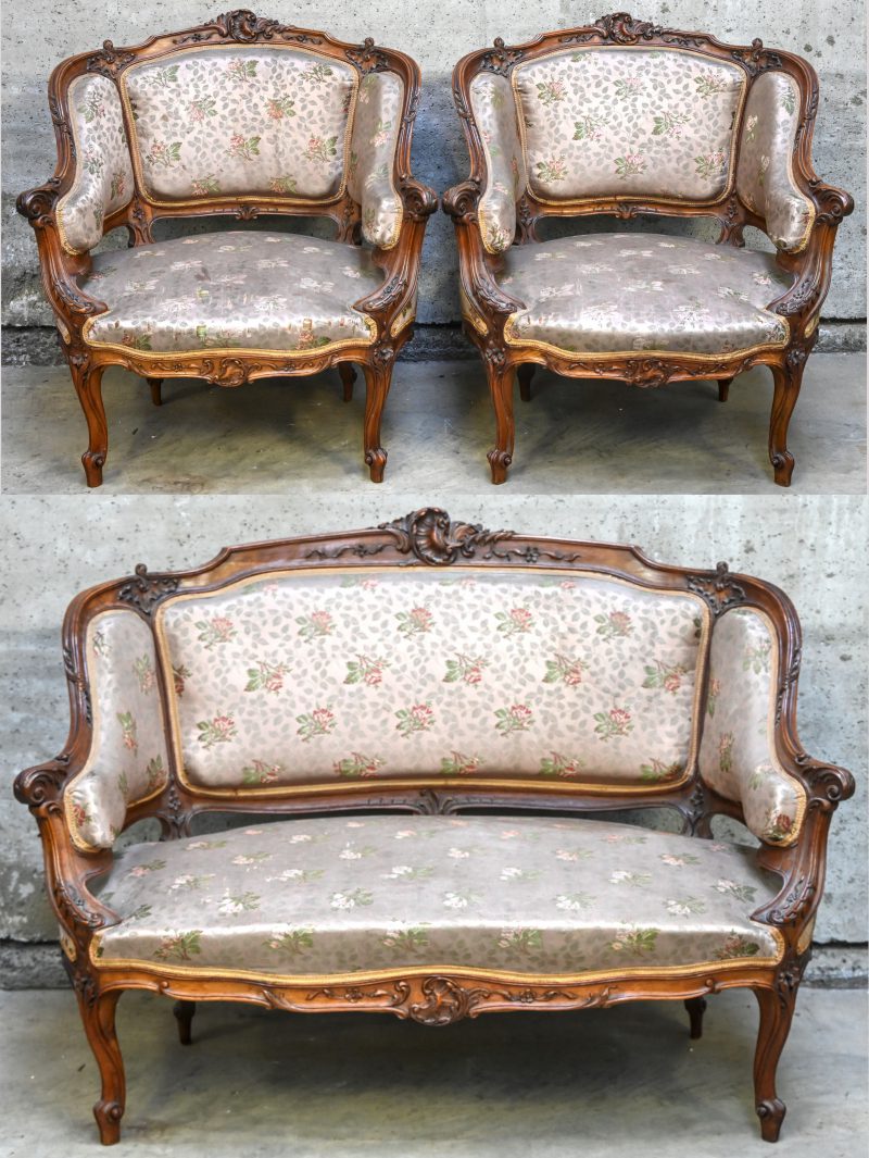 Een salonnetje in Louis XV stijl bestaande uit een 2-zit en 2 fauteuils,  gesculpteerd houtwerk en een bloemenstof.