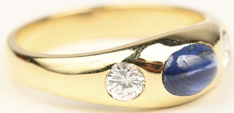 Een 14 kt geelgouden ring bezet met briljanten met een gezamenlijk gewicht van +- 0,40 ct. en een saffier cabochon van +- 0,40 ct.