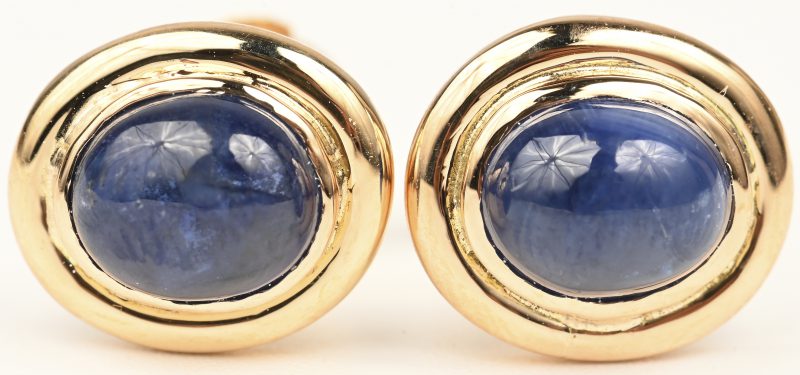 Een paar 18 kt geelgouden oorbellen bezet met en twee saffier cabochons met een gezamenlijk gewicht van +- 1,30 ct.