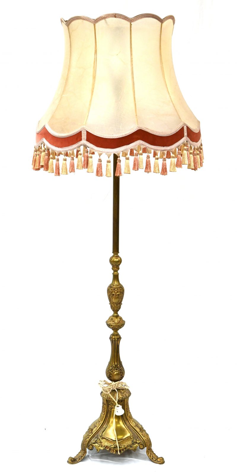 Een staande lamp met uitbundig gedecoreerde massief koperen voet.