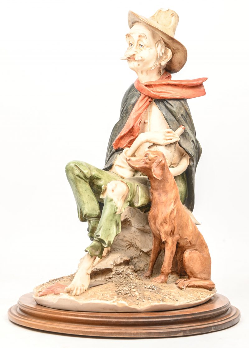 Een groot beeld van een zwerver met hond in meerkleurig gegoten kunststof, gemerkt Capo Di Monte, kleine schade aan de hoed.