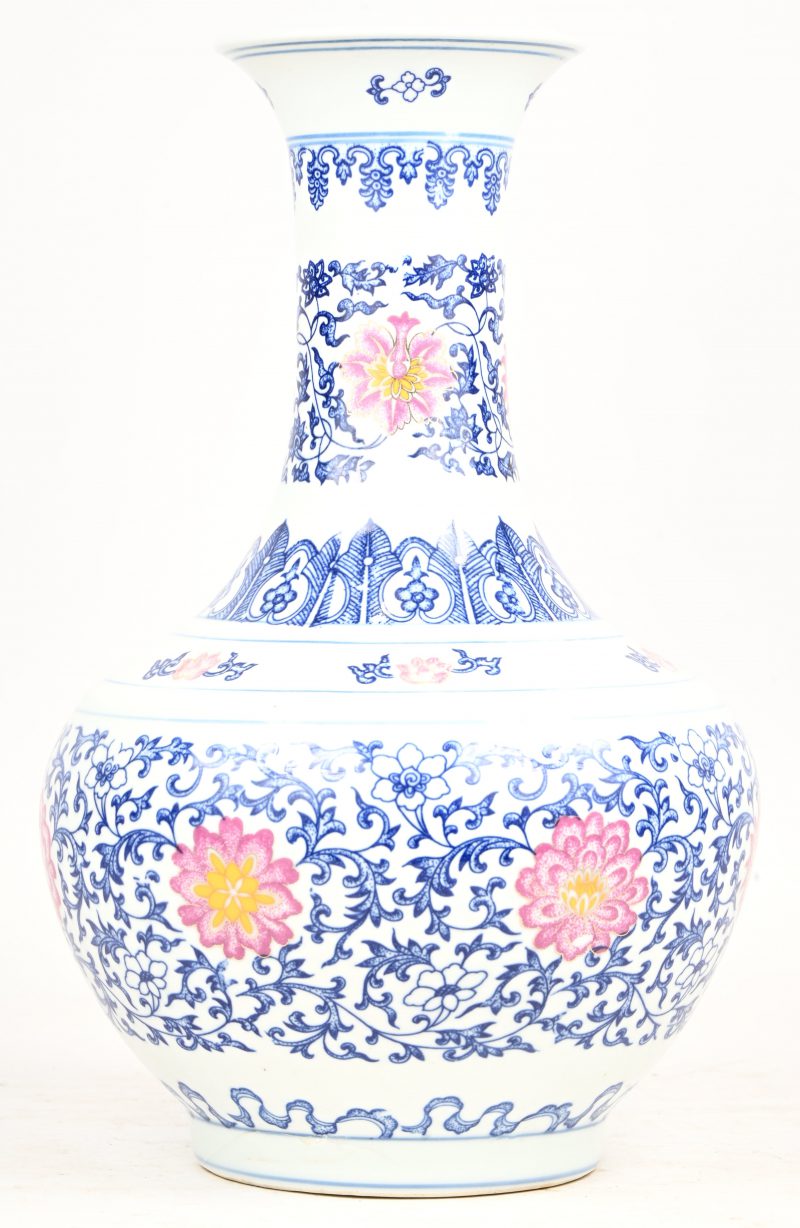 Een Chinees porseleinen vaas met blauw-wit floraal decor, onderaan gemerkt.