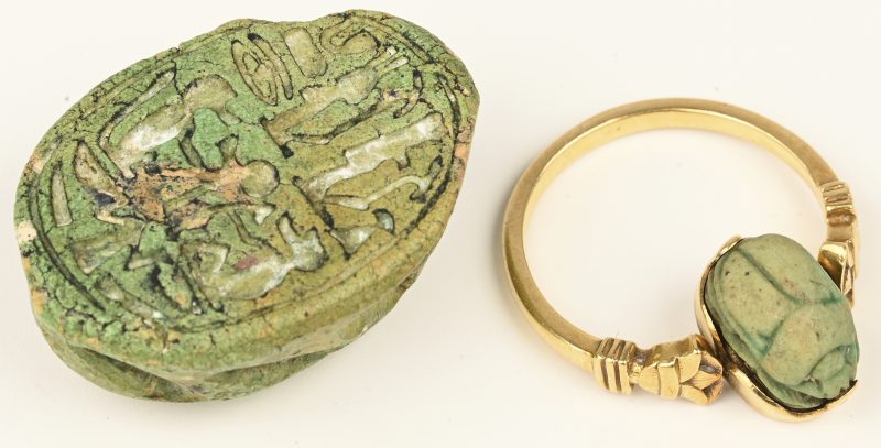 Een 18 kt geelgouden ring met roterend element met groene scarabee. We voegen er een grotere groene scarabee aan toe met hiërogliefen.