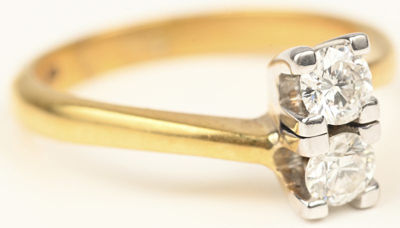 Een 18 kt wit- en geelgouden ring bezet met een centrale briljant van 0,52 ct. F VS1.